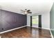 Cozy bedroom featuring dark wood floors, ceiling fan, and a striking accent wall at 6479 Enclave Blvd, Greenwood, IN 46143