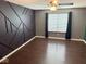 Bedroom featuring dark accent wall with geometric design and hardwood floors at 6479 Enclave Blvd, Greenwood, IN 46143