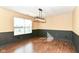 Bright dining room featuring stylish lighting, modern wood paneling, and rich flooring at 6479 Enclave Blvd, Greenwood, IN 46143