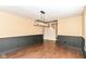 Lovely dining space featuring wood floors, wainscoting, and a modern chandelier at 6479 Enclave Blvd, Greenwood, IN 46143