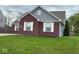 Side view of a brick home with white windows and a well-maintained lawn at 6479 Enclave Blvd, Greenwood, IN 46143