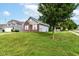 A grassy yard is shown in this charming home's exterior, framed by a large tree at 6479 Enclave Blvd, Greenwood, IN 46143