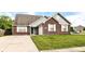 Charming brick home with attached garage, well-maintained lawn, and inviting front entrance at 6479 Enclave Blvd, Greenwood, IN 46143