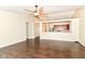 Open-concept living room with hardwood floors, ceiling fan, and a view to the kitchen area at 6479 Enclave Blvd, Greenwood, IN 46143
