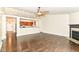 Spacious living room featuring hardwood floors, a ceiling fan, and a cozy fireplace at 6479 Enclave Blvd, Greenwood, IN 46143