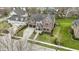 Aerial view of a brick and stone home with a lush lawn and well-kept landscaping in a residential neighborhood at 6590 W Deerfield Dr, Zionsville, IN 46077