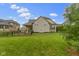 Spacious backyard featuring a covered patio, lush green lawn, and a black fence at 6590 W Deerfield Dr, Zionsville, IN 46077