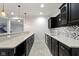 Stylish wet bar in basement featuring granite countertops and dark wood cabinetry at 6590 W Deerfield Dr, Zionsville, IN 46077