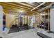 A basement gym is equipped with weightlifting equipment and storage shelves, offering a convenient fitness space at 6590 W Deerfield Dr, Zionsville, IN 46077