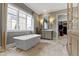 Luxurious bathroom featuring a freestanding tub, large windows, and an adjacent walk-in closet at 6590 W Deerfield Dr, Zionsville, IN 46077