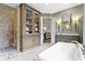 Elegant bathroom featuring a tub, a glass-enclosed shower, a cabinet, and marble floors at 6590 W Deerfield Dr, Zionsville, IN 46077