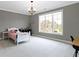 This bedroom has carpet, a large window, gray walls, and white crown molding at 6590 W Deerfield Dr, Zionsville, IN 46077