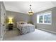 Well-lit bedroom with a comfortable metal bed frame and a decorative chandelier at 6590 W Deerfield Dr, Zionsville, IN 46077