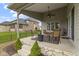 A covered patio features stone accents, a ceiling fan, and outdoor seating for relaxation and entertainment at 6590 W Deerfield Dr, Zionsville, IN 46077