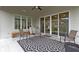 A covered patio boasts a ceiling fan, stylish rug, and comfortable seating, perfect for outdoor relaxation at 6590 W Deerfield Dr, Zionsville, IN 46077