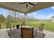 A covered patio is furnished with comfortable seating and offers serene views of the lush green lawn and surrounding trees at 6590 W Deerfield Dr, Zionsville, IN 46077