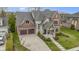 Aerial view of a brick and stone home featuring a well-manicured lawn, and a two car garage at 6590 W Deerfield Dr, Zionsville, IN 46077