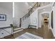 Bright foyer with wooden staircase, wrought iron railing, hardwood floors, and elegant decor at 6590 W Deerfield Dr, Zionsville, IN 46077
