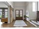 Inviting foyer with hardwood floors, double doors, stylish rug, sliding door, and staircase at 6590 W Deerfield Dr, Zionsville, IN 46077
