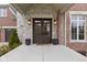 Stunning double front doors framed by stone accents and elegant lighting, creating a grand entrance at 6590 W Deerfield Dr, Zionsville, IN 46077