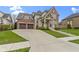Elegant brick home featuring a two-car garage, manicured lawn, and stone detailing on the front facade at 6590 W Deerfield Dr, Zionsville, IN 46077