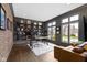 Charming home office with built-in shelving, exposed brick, hardwood floors, and ample natural light at 6590 W Deerfield Dr, Zionsville, IN 46077