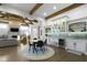 Open-concept living space with beamed ceilings, stone fireplace, bar area, and elegant dining space at 6590 W Deerfield Dr, Zionsville, IN 46077