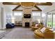 Comfortable living room features a stone fireplace, beamed ceilings, and ample seating at 6590 W Deerfield Dr, Zionsville, IN 46077