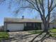 Single story home with a 2 car garage, chimney, and a large tree in the front yard at 6611 Kellum Dr, Indianapolis, IN 46221