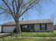 Charming one-story home with attached two-car garage and well-maintained lawn, shaded by a mature tree at 6611 Kellum Dr, Indianapolis, IN 46221