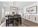 Elegant dining area with modern lighting fixture, stylish sideboard, and open view to living room at 6917 Wheatley Rd, Whitestown, IN 46075