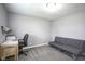 Versatile room features gray walls and carpet, futon sofa, desk, and chair for a modern aesthetic at 712 Valley Dr, Anderson, IN 46011