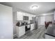 Updated kitchen boasts stainless steel appliances, gray backsplash, white cabinets, and modern gray flooring at 712 Valley Dr, Anderson, IN 46011