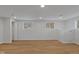 Well-lit basement with hardwood floors, neutral paint, and large windows provides a versatile living space at 7171 N Orchard Dr, Indianapolis, IN 46236
