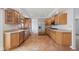 Spacious kitchen features plenty of oak cabinetry, stainless steel appliances, and tile flooring in a neutral color palette at 7171 N Orchard Dr, Indianapolis, IN 46236