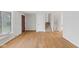 Hardwood floors, white walls, and staircase in this inviting living room with a window and a door with decorative accents at 7171 N Orchard Dr, Indianapolis, IN 46236