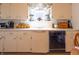 Well-lit kitchen with white cabinetry, a practical layout, and a window with patterned curtains at 720 22Nd St, Columbus, IN 47201