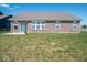Spacious backyard featuring a well-maintained lawn, brick house, and blue sky at 7209 Glen Park Ln, Indianapolis, IN 46259
