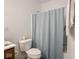 Bathroom with a toilet and tub-shower combination with a blue shower curtain at 7209 Glen Park Ln, Indianapolis, IN 46259