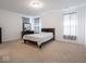 Spacious bedroom with neutral carpet, windows with dark curtains, and a dresser with a mirror at 7209 Glen Park Ln, Indianapolis, IN 46259
