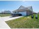A large concrete driveway leads to an attached two-car garage with a manicured lawn at 7209 Glen Park Ln, Indianapolis, IN 46259