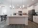 Bright kitchen boasts white cabinetry, stainless steel appliances, and an island with breakfast bar seating at 7209 Glen Park Ln, Indianapolis, IN 46259
