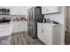Well-lit kitchen featuring stainless steel refrigerator and white cabinets and tile backsplash at 7209 Glen Park Ln, Indianapolis, IN 46259