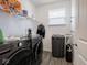 Well-equipped laundry room with modern washer, dryer, and a water filtration system at 7209 Glen Park Ln, Indianapolis, IN 46259