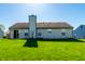 A nice backyard featuring a well-maintained lawn and a home with a sliding glass door at 7230 Carrie Dr, Indianapolis, IN 46237