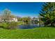 Expansive backyard featuring lush green grass, mature trees, and a pond with fountain at 7230 Carrie Dr, Indianapolis, IN 46237