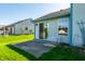 Home exterior featuring a back patio, grassy yard, light siding, and trees at 7230 Carrie Dr, Indianapolis, IN 46237