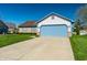Lovely home with a blue garage door and well-maintained front lawn under a clear blue sky at 7230 Carrie Dr, Indianapolis, IN 46237