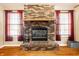 Detailed view of a brick fireplace with a wooden mantle and a brick hearth, adding warmth to the living space at 7230 Carrie Dr, Indianapolis, IN 46237