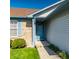 Close-up of the home's entrance showing the light blue front door, brick accents, and manicured landscaping at 7230 Carrie Dr, Indianapolis, IN 46237